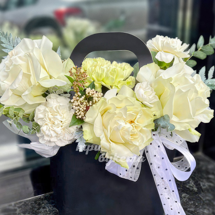 Коробочка белых диантусов и французских роз (крупный план)